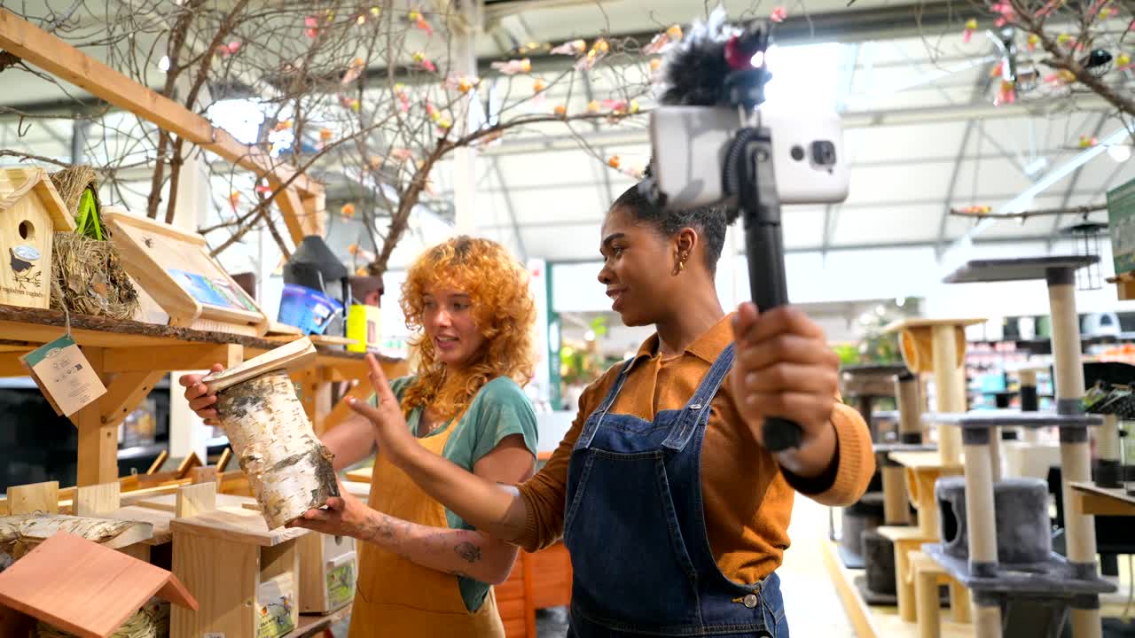 Two women blogging about birdhouses in a pet store