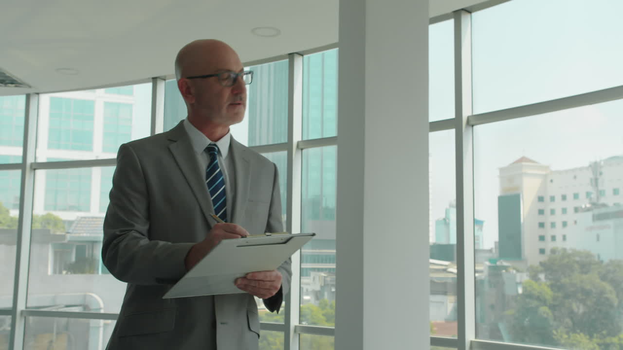 Serious Businessman Checking Contract when Visiting Office