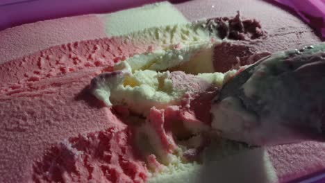 helado a rayas con tema de barbie con sabor a fresa, vainilla y corriente negra en tina rosa, delicioso postre dominical servido con una cuchara de acero inoxidable