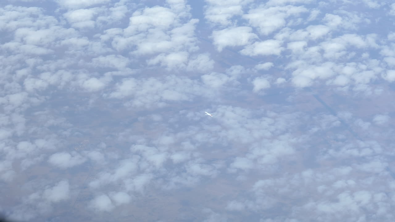 위의 조종석에서 본 구름 위를 비행하는 먼 여객기