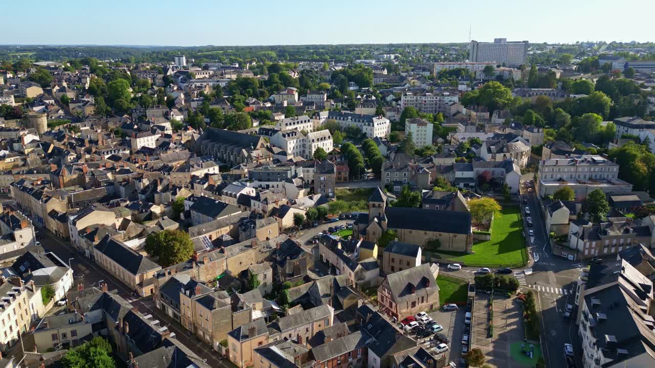 Panorama aereo di Laval con fitti tetti urbani, strade e vegetazione circostante in una giornata limpida, creando uno sfondo.