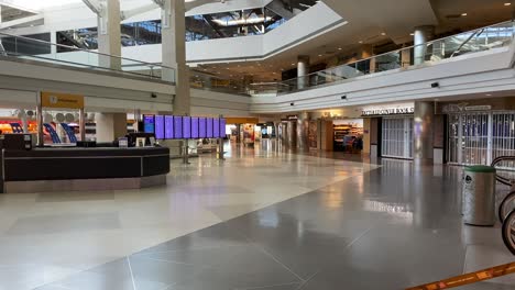 steady shot of empty denver international airport terminal departure and arrival screens