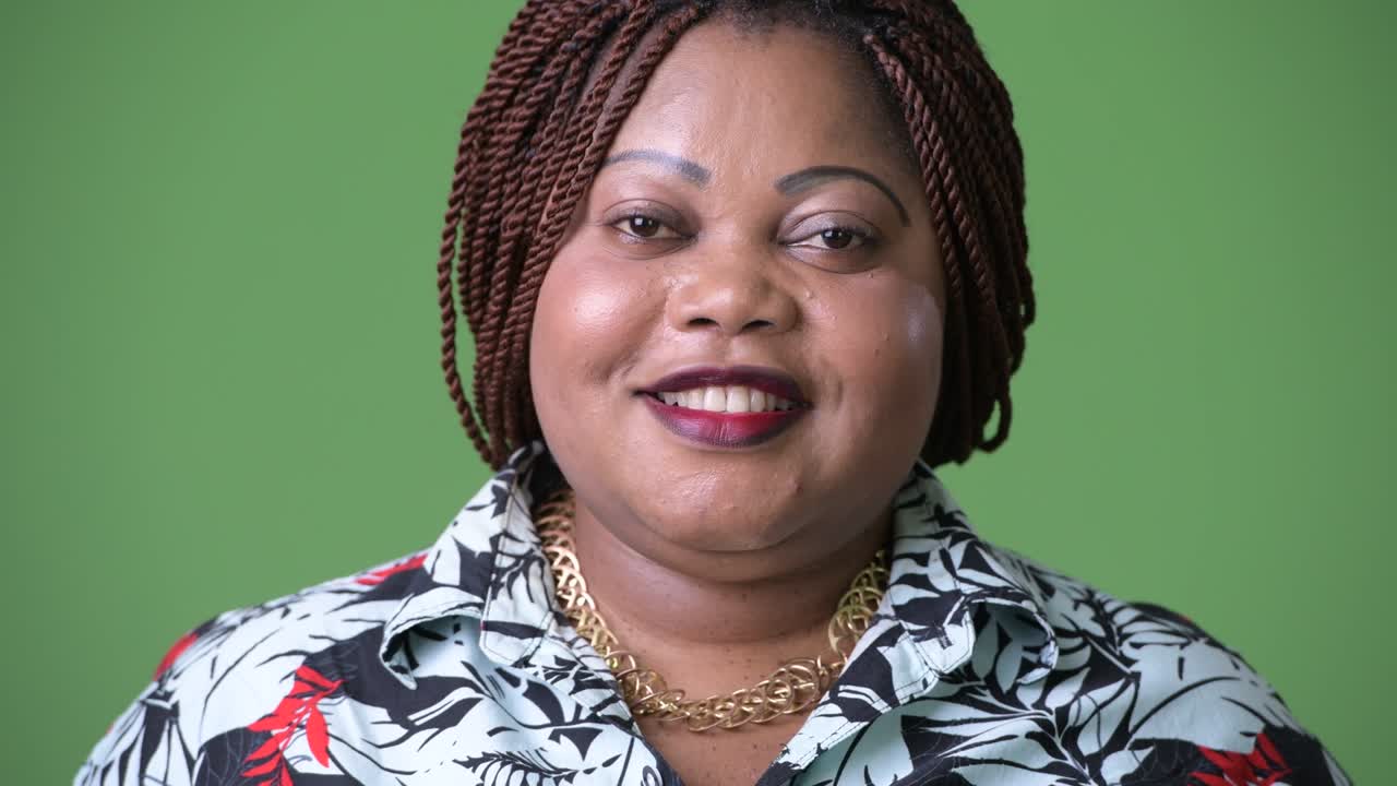 Krásná africká žena s nadváhou na zeleném pozadí.