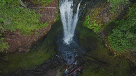 lower section of falls creek falls splashing into pool at base of falls, gifford pinchot national forest, top down static aerial view.