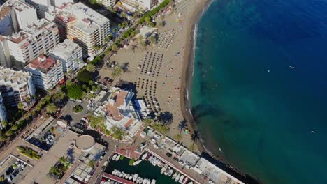 Drone-shot-of-a-small-corner-beach-by-the-promenade-in-Marbella