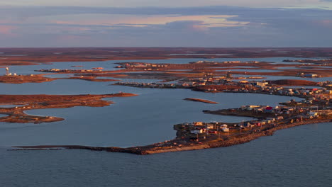 aerial view of a remote arctic coastal town at sunset