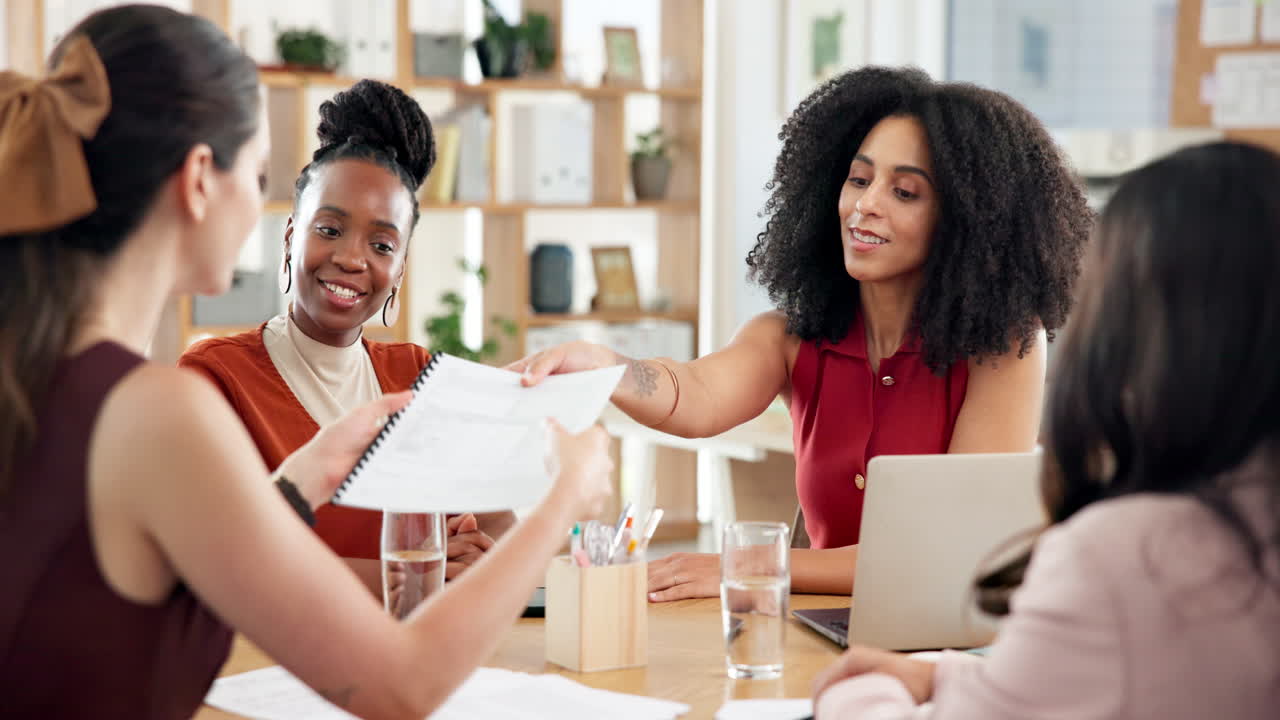 Diverse Businesswomen Collaborating and Discussing Documents in a Modern Office Meeting
