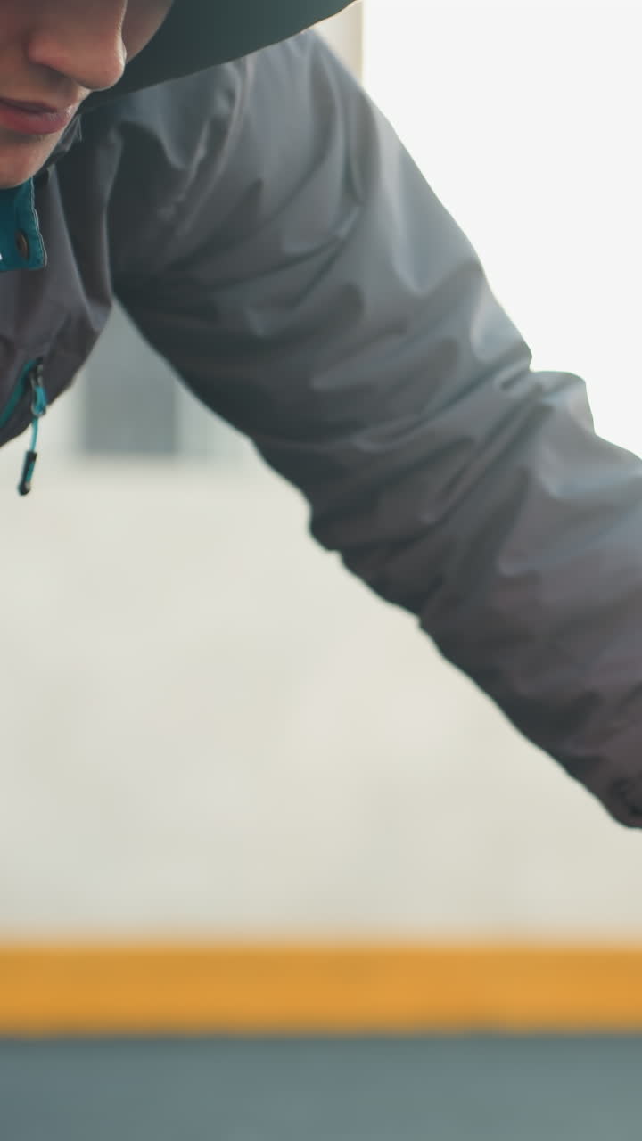 primer plano de un deportista realizando flexiones alternando la colocación de la mano en la pelota de fútbol mostrando fuerza, coordinación y agilidad en una arena urbana al aire libre con edificio residencial