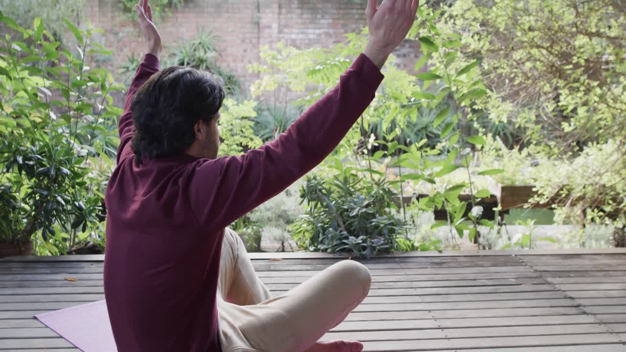 백인 남자가 태양이 비치는 자연 속에서 테라스에서 요가 명상을 연습하고 있습니다. 복사 공간, 느린 동작