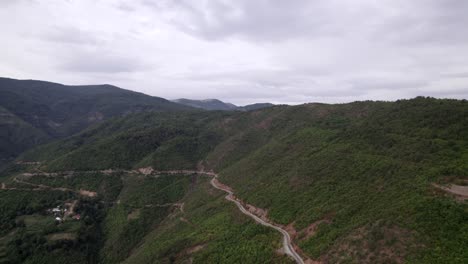 "golden hour" head-on drone video moving over the mountains of sh22 in albania, above the road on top of the hill