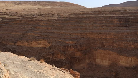 Arid-Mides-Canyon-under-clear-skies-in-Tunisia,-showcasing-geological-layers