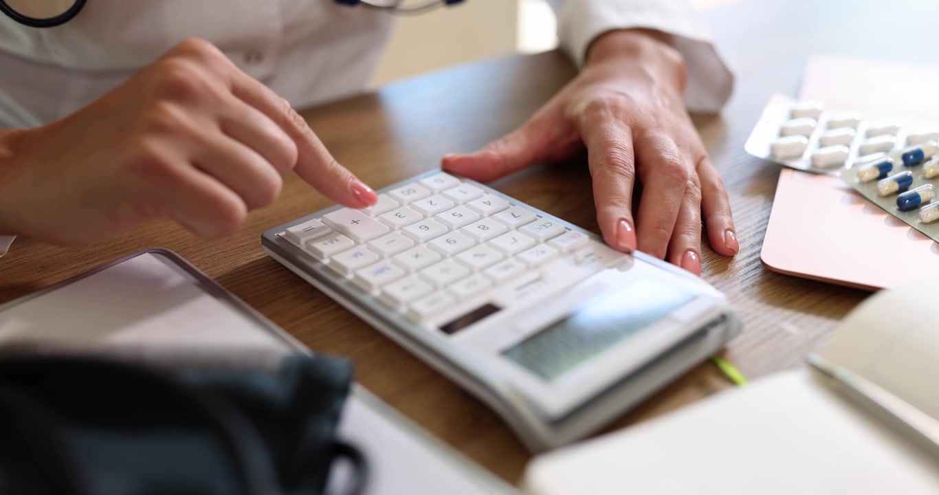 Un professionista sanitario che utilizza una calcolatrice per calcoli medici precisi e analisi.