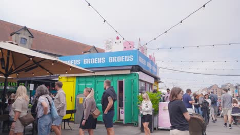 busy outdoor food market with colorful shipping container stalls
