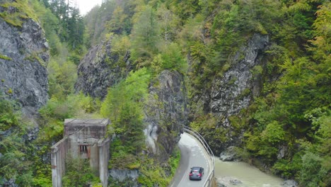 aerial follow shot of car driving along winding road in eisenkappel vellach, austria