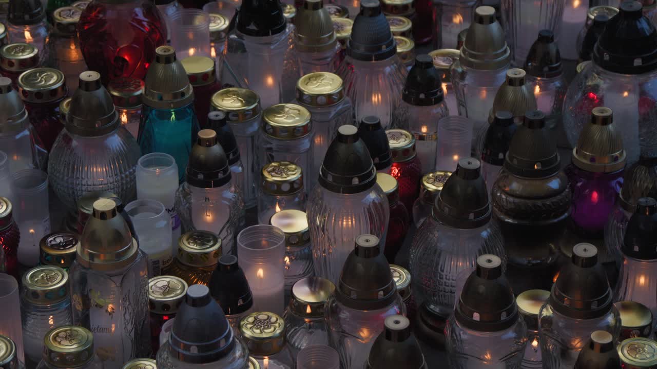 Memory Candles and votive lights standing in cementary during All Saints' Day
