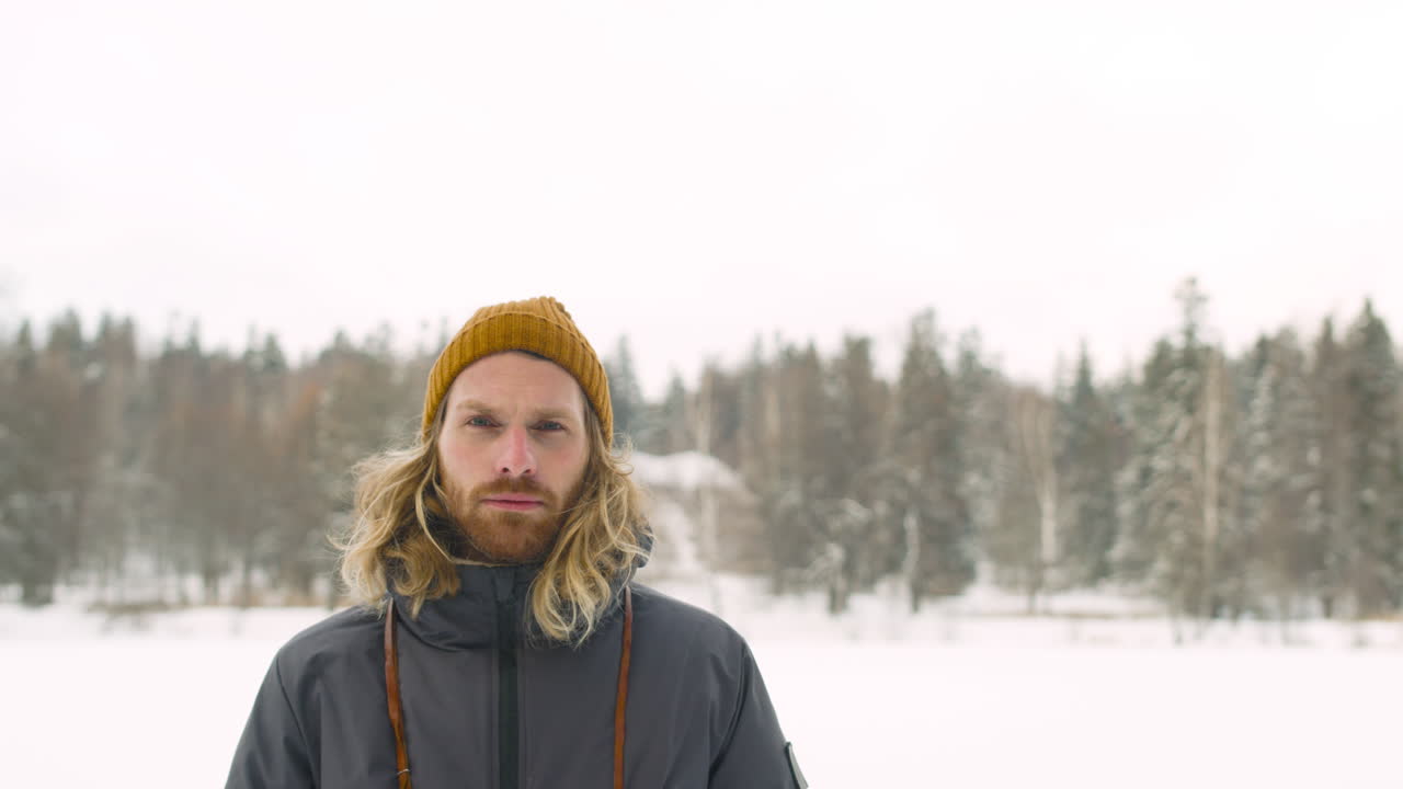 겨울 숲에서 카메라를 보고 겨울 옷에 남자의 전면 보기
