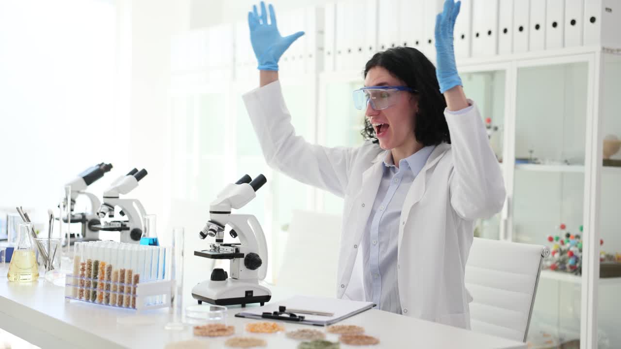 Excited scientist in a lab with microscopes and test tubes