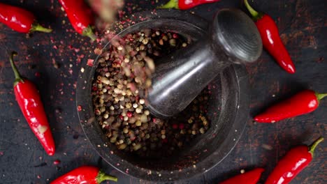 peas of black pepper falls into the mortar.