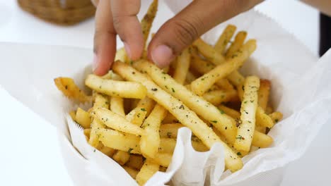 Hand-pick-french-fries-on-table-,