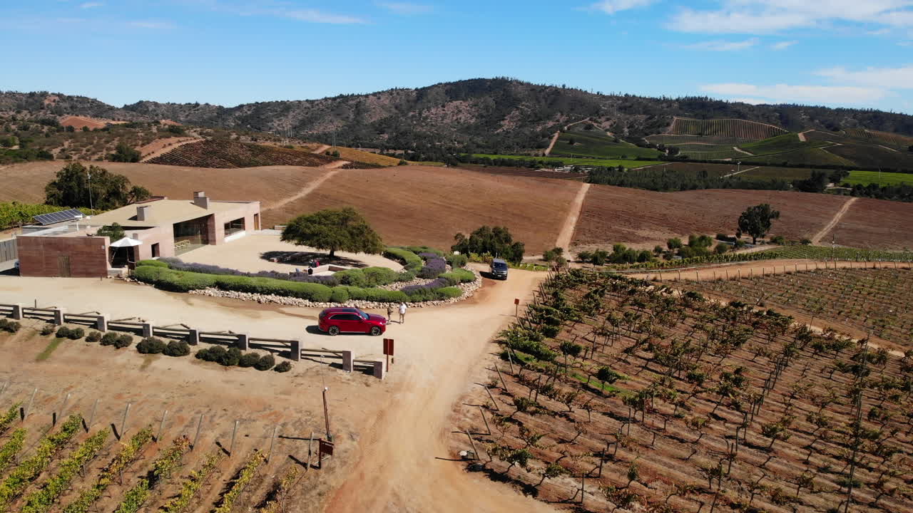 Vineyard landscape with building and cars