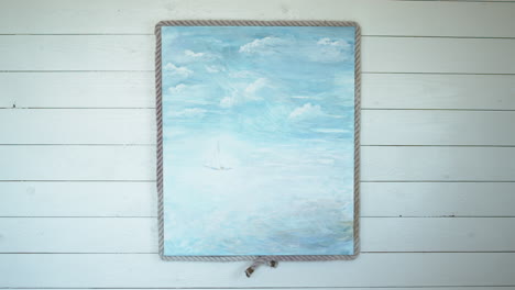 Acrylic-painting-of-a-sailing-boat-at-sea-hanging-on-a-wooden-wall-in-a-seaside-cabana