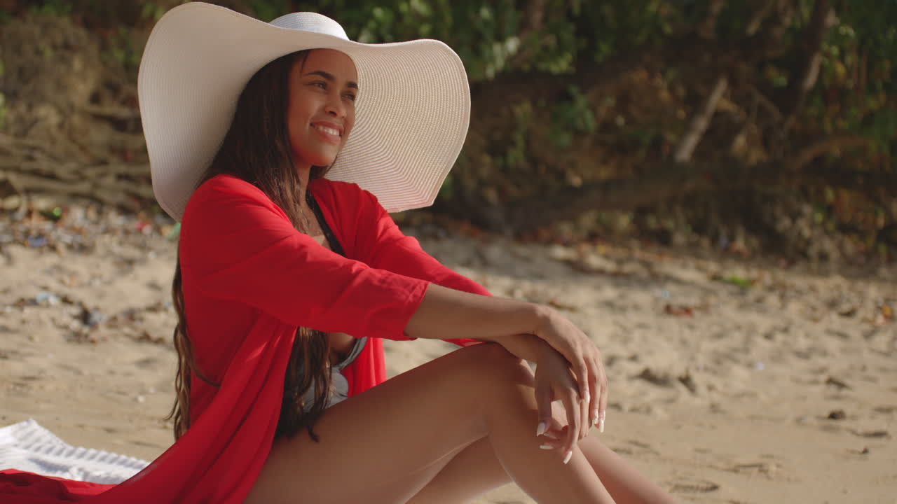 카메라에 대 한 포즈 동안 해변 미소에 스타일 옷을 입고 젊은 성인 여성 라틴 모델