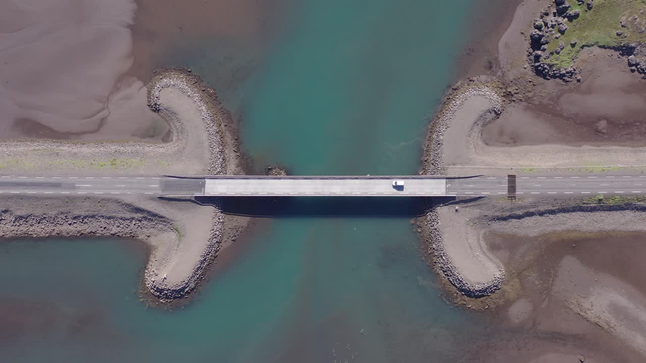 coche que cruza el puente en la entrada del rompeolas del delta del río en el fiordo breiðdalsvík