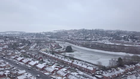 Track-forward-panning-drone-shot-of-snowy-Exeter-over-the-River-Exe