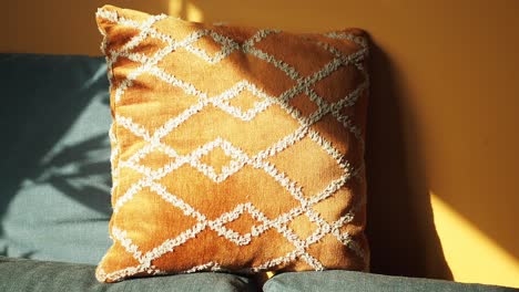 orange geometric patterned pillow on sofa