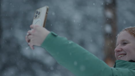 happy woman taking a selfie in the snow