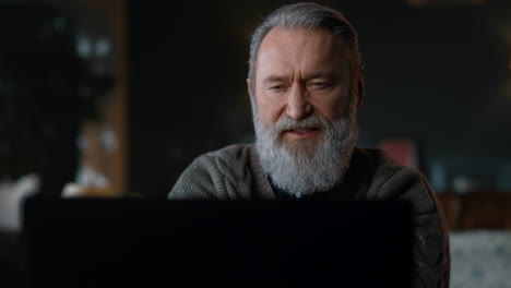 Bearded-old-man-having-video-call-computer-indoors.-Senior-businessman-using-pc.