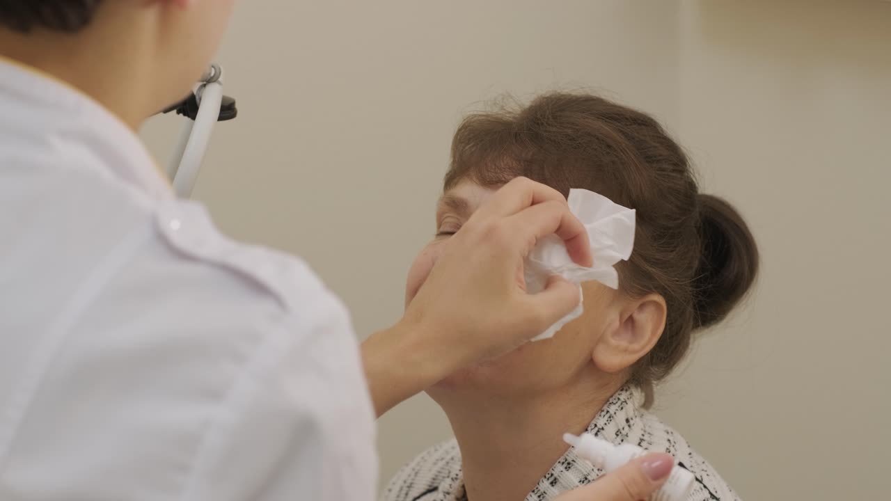 Optometrista aplicando gotas en los ojos del paciente en una clínica oftalmológica