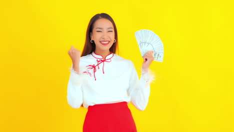 a pretty young woman hides her face with a fan for one hundred dollar bills