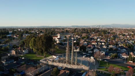 aerial panning shot of the watts towers with downtown los angeles in the distance