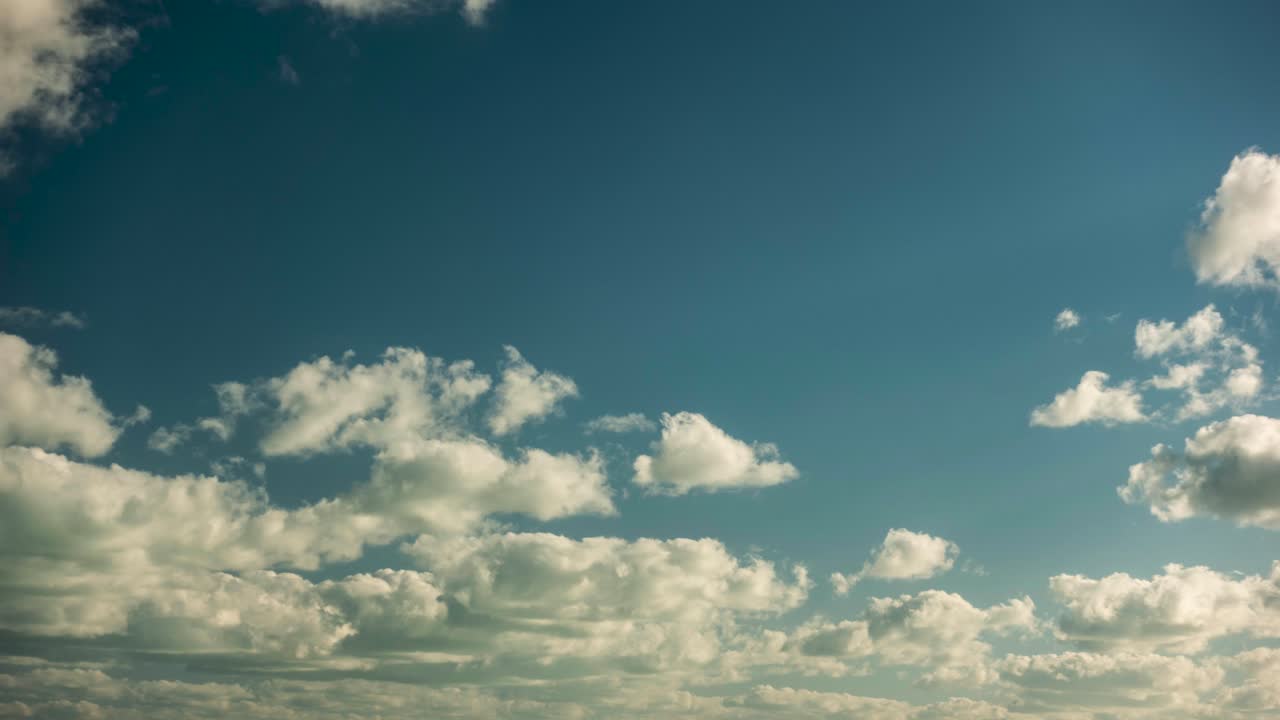 White rolling white clouds in a blue sky time lapse