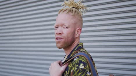 portrait of smiling albino african american man with dreadlocks looking at camera