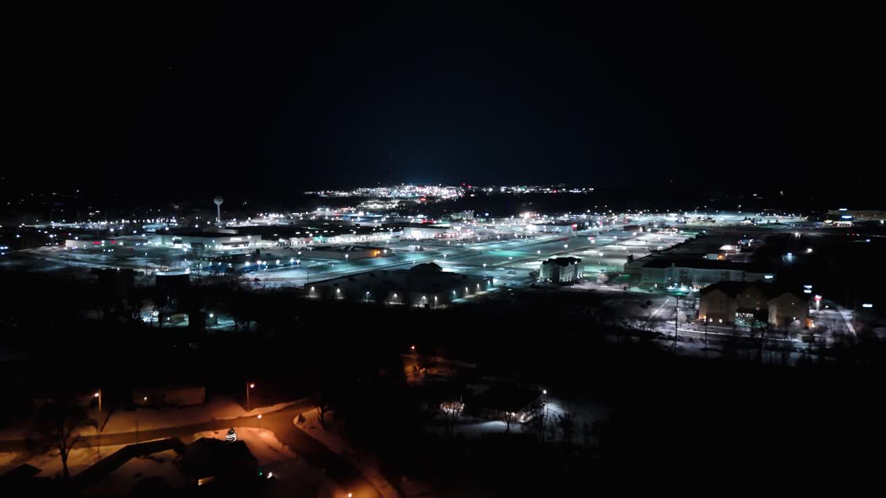 Aerial shot pulling out from The Millcreek Mall at night in Erie in the winter.