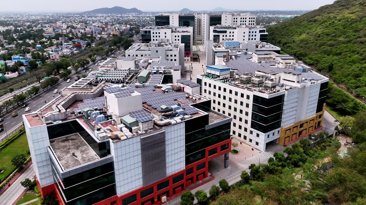 Aerial view of glass and white commercial buildings in a business park. Prominent solar arrays cover the rooftops. conveys themes of technology, corporate growth, and environmental responsibility