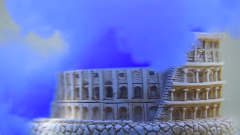 slow motion and close up of colosseum underwater with blue water ink swirling around it