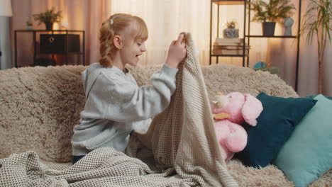 young teenager girl singing lullaby for plush bunny toy at home sofa bedtime pretend care sleeping
