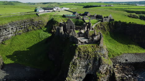 Aerial-shot-of-stunning-ruins-of-Dunluce-Castle-upon-Northern-Irish-clifftop