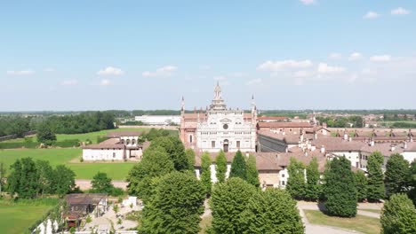 Aerial-view-of-the-Certosa-di-Pavia-at-sunny-day,-built-in-the-late-fourteenth-century,-courts-and-the-cloister-of-the-monastery-and-shrine-in-the-province-of-Pavia,-Lombardia,-Italy