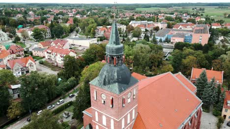 A-church-tower-against-the-backdrop-of-a-picturesque-town-seen-from-a-drone