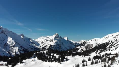 drone view of snow-covered mountain ranges in warth, a small municipality in vorarlberg, austria on a beautifully clear and sunny day in 4k