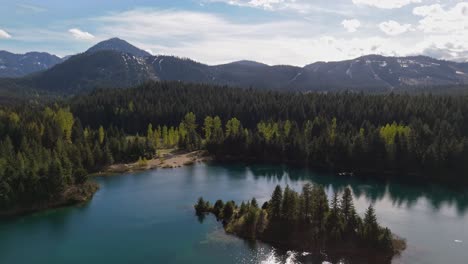 Majestuosa-Vista-De-Volar-Sobre-El-Estanque-Gold-Creek-Y-El-Bosque-Siempre-Verde-En-Un-Día-De-Cielo-Azul-En-El-Estado-De-Washington