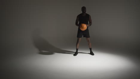 Studio-Actionaufnahme-Eines-Männlichen-Basketballspielers,-Der-Den-Ball-Vor-Weißem-Hintergrund-Dribbelt-3