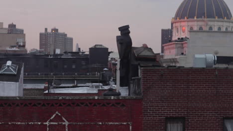 nyc metro train carries commuters above brooklyn rooftops, early morning pink sunrise