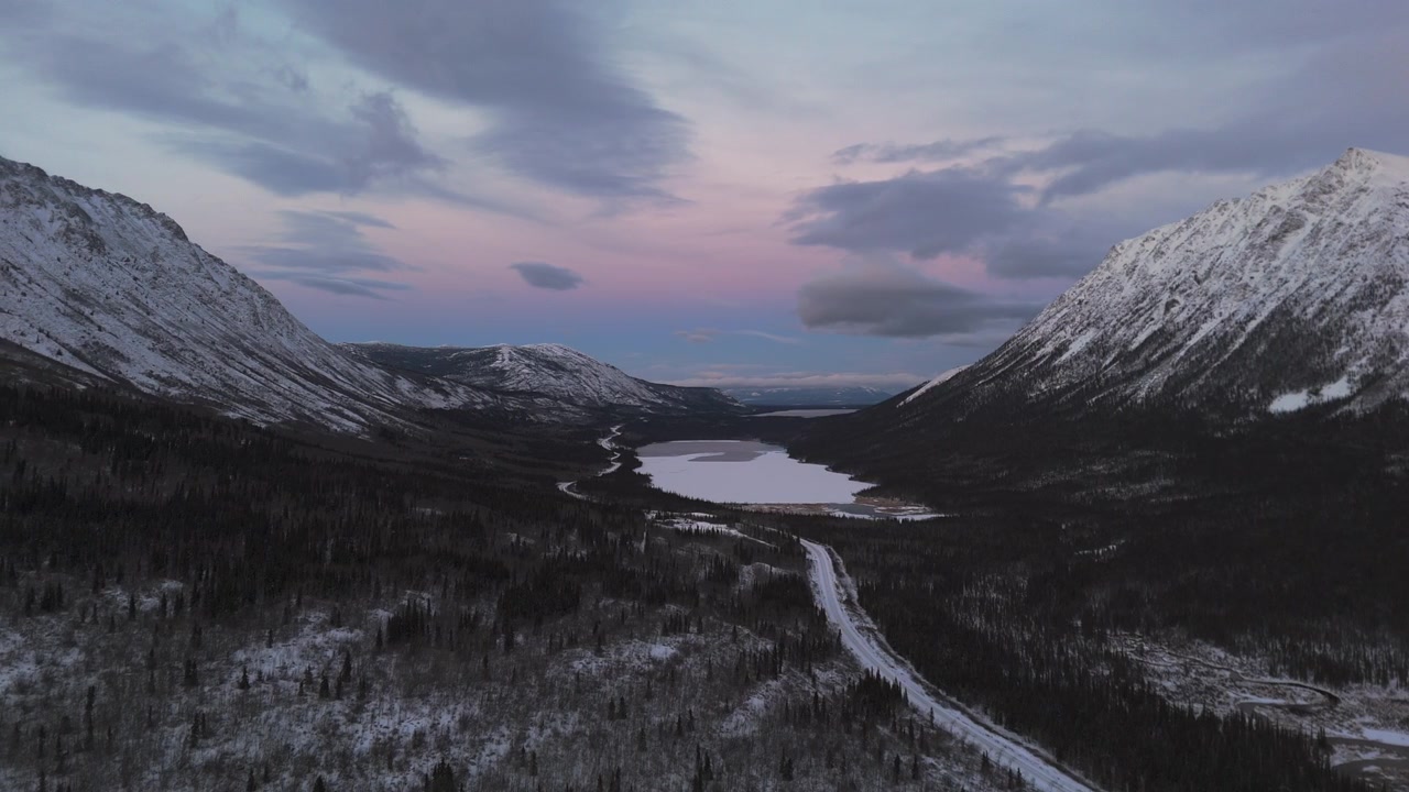 Lago Crag tra montagne innevate al tramonto nel Territorio dello Yukon, Canada. Ampia ripresa con drone.