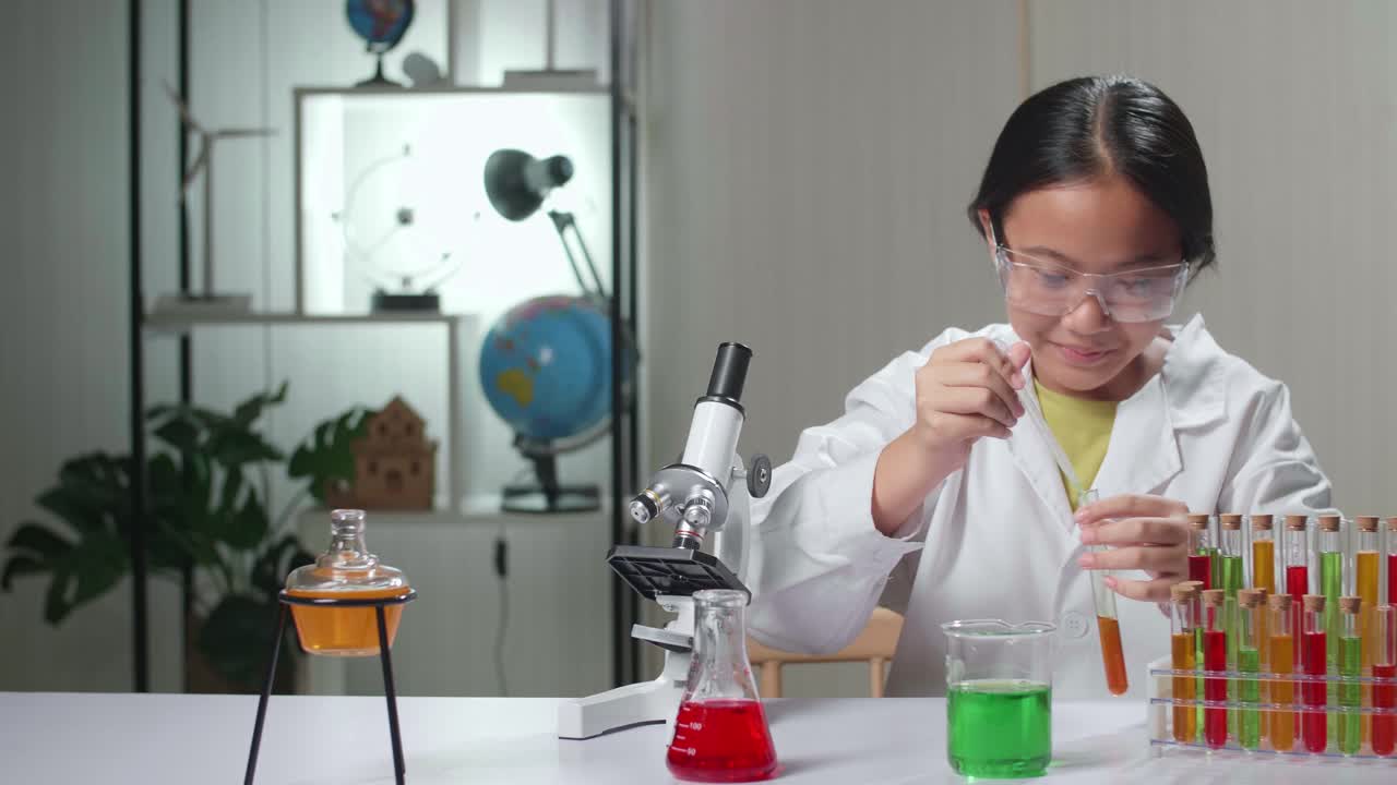 Excited Young Asian Scientist Girl Mixes Chemicals In Test Tube. Child Learn With Interest