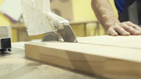 carpenter using a table saw to cut wood